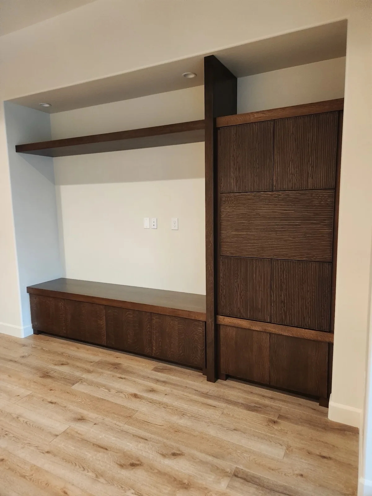 Built-in media wall in dark oak with fluted door panels