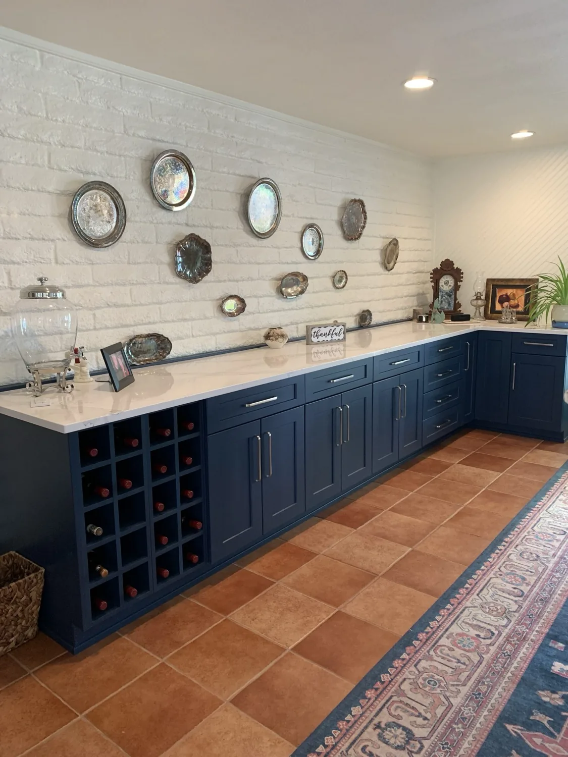 Navy wine and serving wall with open bottle storage against white brick